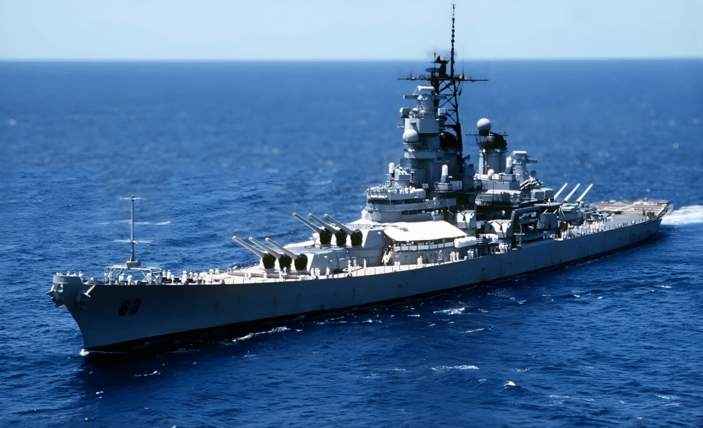 Aerial view of a U.S. Navy Iowa-class battleship sailing through open ocean waters.